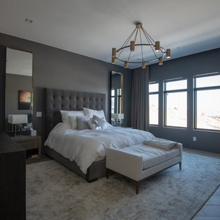 Modelo de dormitorio principal, contemporáneo, de tamaño medio, sin chimenea, con paredes grises, suelo de baldosas de porcelana y suelo gris