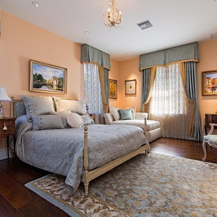 Example of a large french country master dark wood floor bedroom design in Miami with orange walls