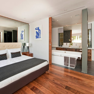 Foto di una camera da letto minimalista con pareti bianche e pavimento in legno massello medio