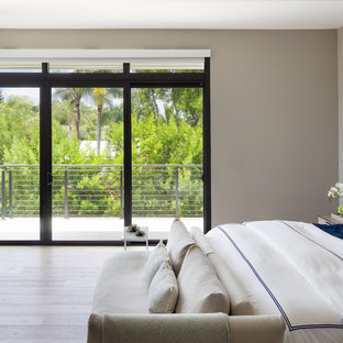 Modelo de dormitorio principal, contemporáneo, grande, con paredes beige, suelo de piedra caliza y suelo beige