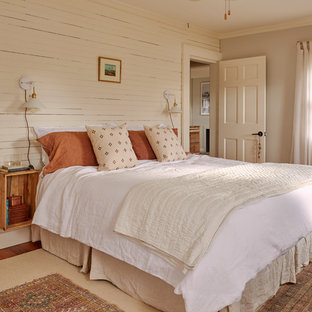 Cette image montre une chambre rustique avec un mur beige et du lambris.