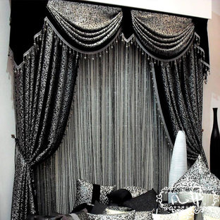 Imagen de dormitorio principal, moderno, grande, con paredes negras, suelo de ladrillo, chimeneas suspendidas, marco de chimenea de yeso y suelo negro