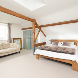 Photo of a farmhouse bedroom in Kent with white walls, carpet and grey floors.