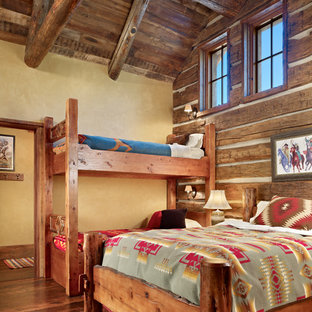 Ejemplo de habitación de invitados rústica, de tamaño medio, con paredes amarillas y suelo de madera en tonos medios