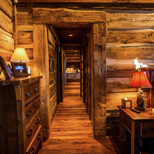 Foto de habitación de invitados rural, de tamaño medio, con paredes marrones y suelo de madera oscura