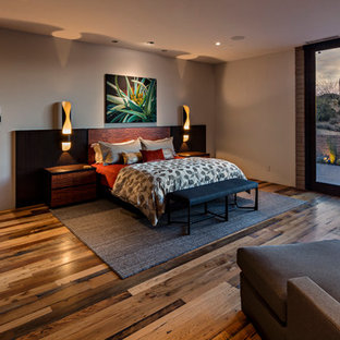 Diseño de dormitorio principal, actual, grande, sin chimenea, con paredes beige, suelo de madera en tonos medios y suelo multicolor