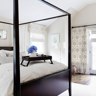Traditional bedroom in New York with beige walls and dark hardwood floors.