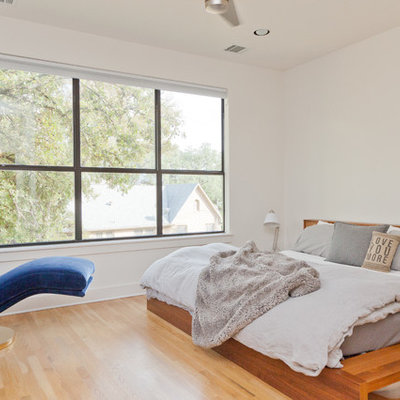 Example of a trendy light wood floor bedroom design in Austin with white walls