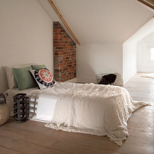 Diseño de dormitorio tipo loft, bohemio, de tamaño medio, con paredes blancas y suelo de contrachapado