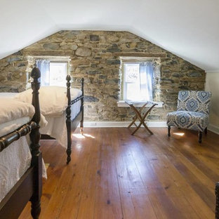 Modelo de habitación de invitados clásica, pequeña, con paredes negras, suelo de madera en tonos medios, chimenea lineal y suelo marrón