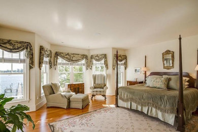 Foto de dormitorio principal tradicional de tamaño medio sin chimenea con paredes beige, suelo de madera en tonos medios y suelo beige