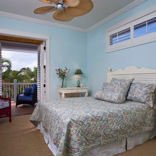 Diseño de dormitorio tropical, sin chimenea, con paredes azules y moqueta