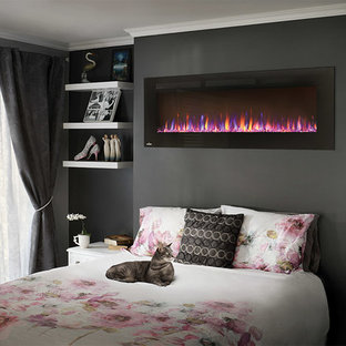 Imagen de dormitorio principal, minimalista, de tamaño medio, con paredes negras, chimenea lineal y marco de chimenea de yeso
