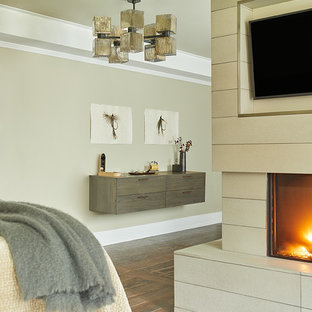 Ejemplo de dormitorio principal, contemporáneo, grande, con paredes beige, suelo de baldosas de cerámica, chimenea de doble cara y marco de chimenea de hormigón