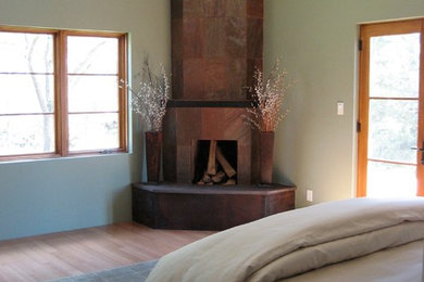 アルバカーキにある中くらいなトランジショナルスタイルのおしゃれな主寝室 (緑の壁、竹フローリング、コーナー設置型暖炉、タイルの暖炉まわり)