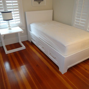 Ejemplo de habitación de invitados costera, pequeña, con paredes blancas, suelo de madera oscura y suelo multicolor