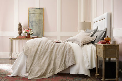 Modelo de dormitorio principal romántico de tamaño medio con paredes rosas y suelo de madera clara