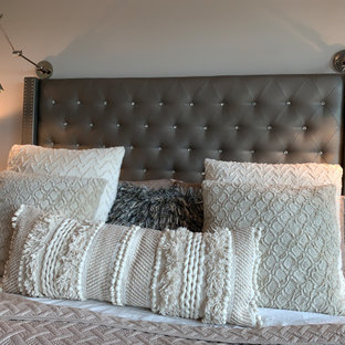 Großes Klassisches Hauptschlafzimmer mit grauer Wandfarbe, Porzellan-Bodenfliesen, Hängekamin, gefliester Kaminumrandung, beigem Boden und freigelegten Dachbalken