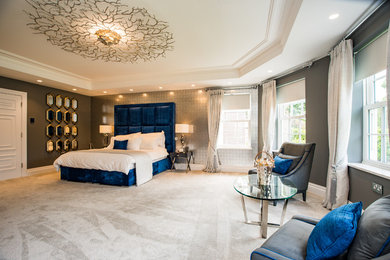 バッキンガムシャーにあるトランジショナルスタイルのおしゃれな主寝室 (グレーの壁、カーペット敷き、ベージュの床) のレイアウト