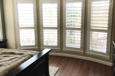 Elegant master medium tone wood floor bedroom photo in Dallas