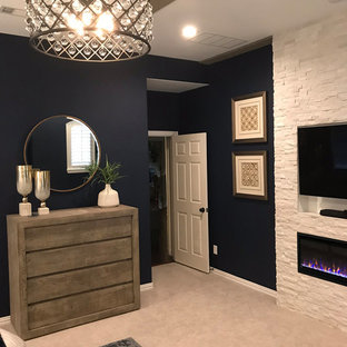 Diseño de dormitorio principal, contemporáneo, grande, con paredes azules, moqueta, chimenea tradicional, marco de chimenea de piedra y suelo gris