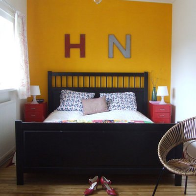 Bedroom - eclectic medium tone wood floor bedroom idea in Amsterdam with yellow walls and no fireplace