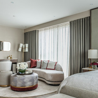 Large contemporary master bedroom in London with no fireplace, beige walls and dark hardwood flooring.