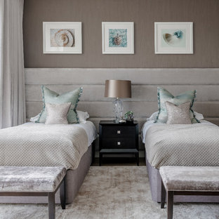 Photo of a large contemporary guest bedroom in London with no fireplace and grey walls.