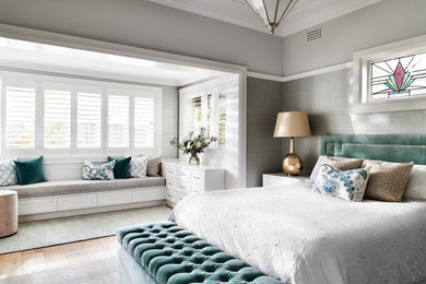Diseño de dormitorio principal tradicional renovado grande con paredes grises, suelo de madera clara y suelo beige