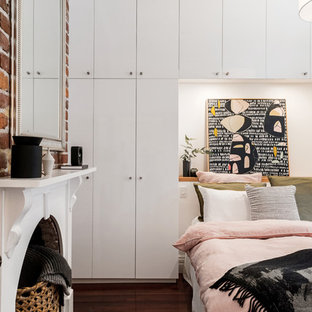 Inspiration for a small eclectic master bedroom in Perth with white walls, dark hardwood floors, brown floor and a standard fireplace.