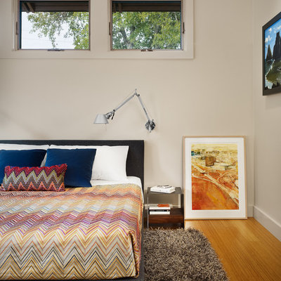 Bedroom - modern master medium tone wood floor bedroom idea in Austin with beige walls