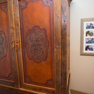 Ejemplo de habitación de invitados de estilo americano, grande, con parades naranjas, suelo de madera oscura y suelo marrón