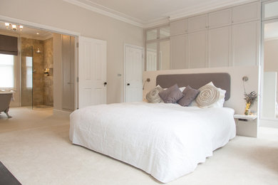 Inspiration for a contemporary master bedroom in London with beige walls and carpet.