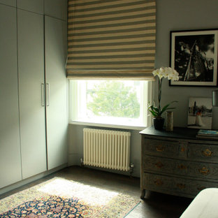 Foto de dormitorio principal, de tamaño medio, con paredes verdes, suelo de madera oscura y suelo verde
