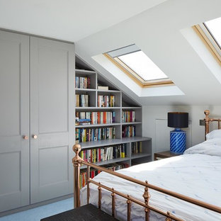 This is an example of a small traditional bedroom in London with white walls and blue floors.