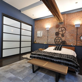 Ejemplo de dormitorio tipo loft, urbano, de tamaño medio, sin chimenea, con suelo de madera oscura, paredes azules y suelo marrón