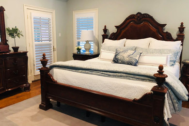 Bedroom - large transitional master medium tone wood floor and brown floor bedroom idea in New Orleans with blue walls and no fireplace