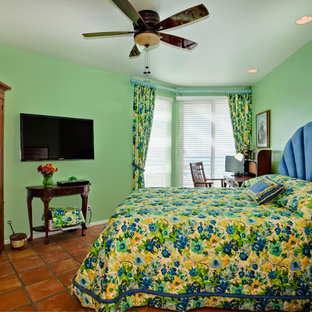Modelo de dormitorio principal, tropical, de tamaño medio, sin chimenea, con paredes verdes y suelo de baldosas de terracota