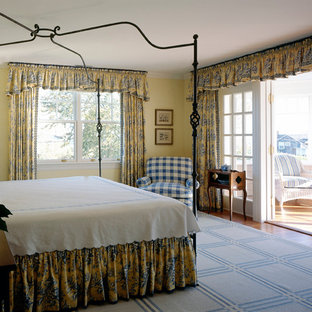 Diseño de dormitorio principal, tradicional, de tamaño medio, con paredes amarillas y moqueta