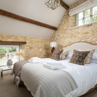Photo of a medium sized farmhouse guest bedroom in Gloucestershire with beige walls, carpet and beige floors.