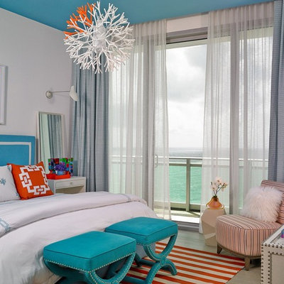 Mid-sized beach style master light wood floor and gray floor bedroom photo in Miami with white walls and no fireplace