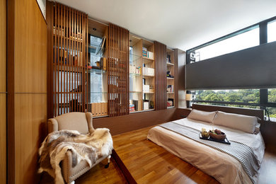 Ejemplo de dormitorio contemporáneo con paredes marrones, suelo de madera en tonos medios y suelo marrón