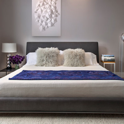 Mid-sized trendy master medium tone wood floor and brown floor bedroom photo in New York with gray walls and no fireplace