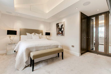 Photo of a medium sized contemporary master bedroom in London with white walls and carpet.