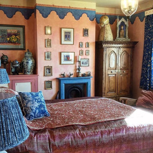 Modelo de habitación de invitados de estilo zen, grande, con parades naranjas, moqueta, chimenea tradicional, marco de chimenea de madera y suelo beige
