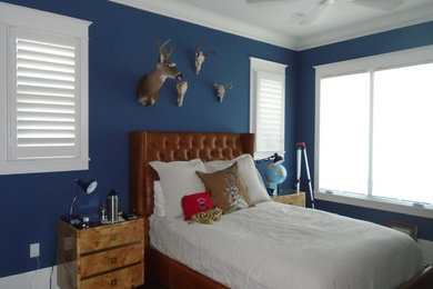Imagen de habitación de invitados bohemia de tamaño medio con paredes azules y suelo de madera oscura