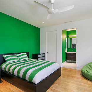 Imagen de habitación de invitados moderna, de tamaño medio, sin chimenea, con paredes verdes, suelo de bambú y suelo multicolor