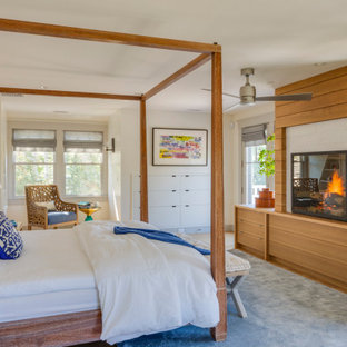 Imagen de dormitorio principal, marinero, con paredes blancas, suelo de madera clara y estufa de leña