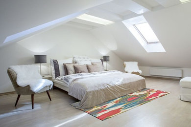 Imagen de dormitorio tipo loft contemporáneo de tamaño medio sin chimenea con paredes blancas y suelo de madera clara