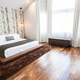 Diseño de dormitorio principal, contemporáneo, de tamaño medio, sin chimenea, con paredes blancas, suelo marrón y suelo de bambú